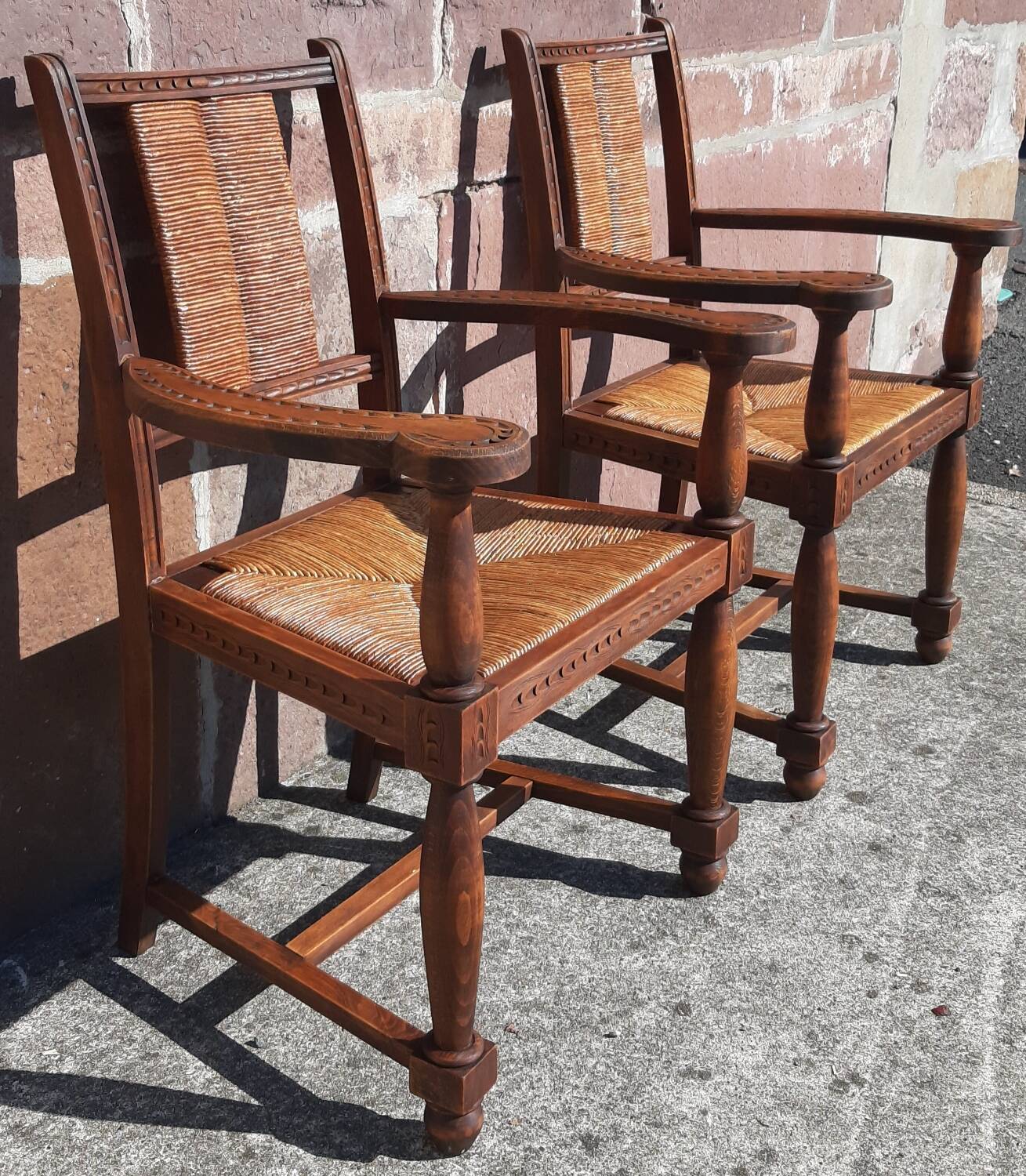 Pair of oak armchairs with straw seats and backs.