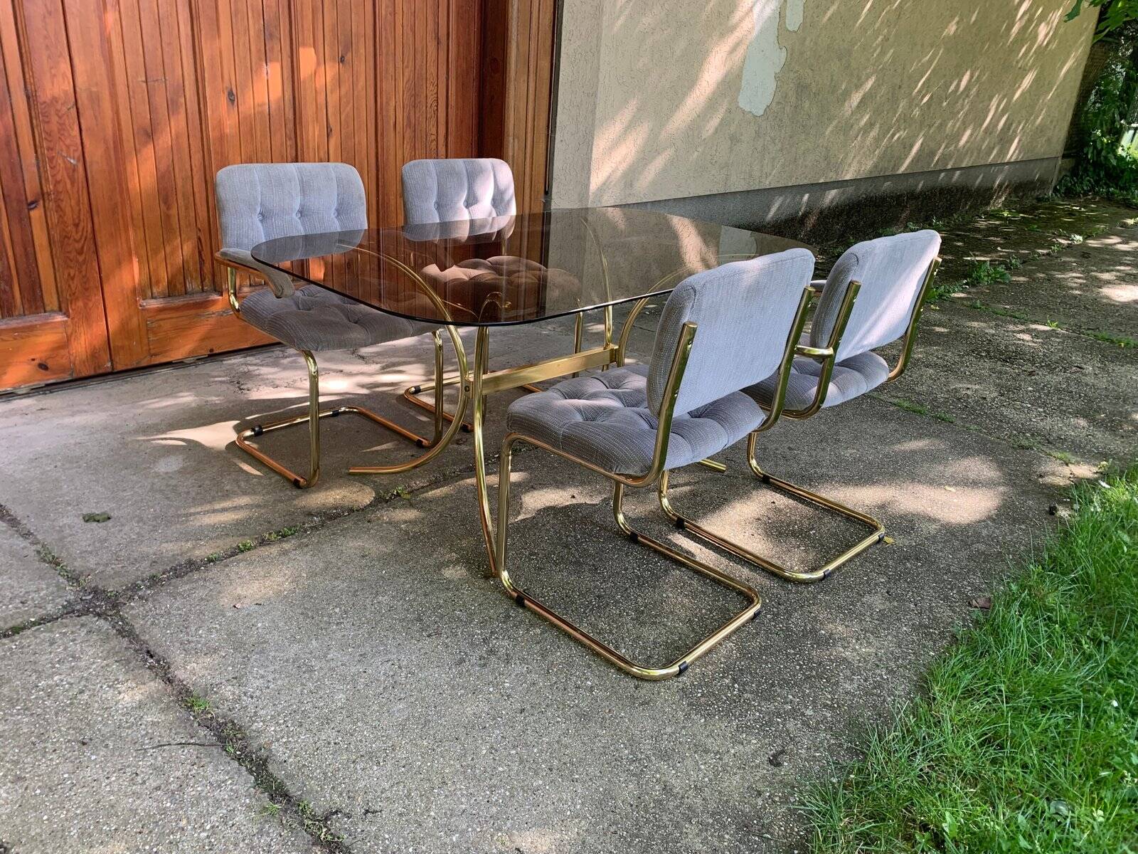 1970s table set with 4 chairs in gold brass and grey fabric, smoked glass top.