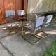 1970s table set with 4 chairs in gold brass and grey fabric, smoked glass top.