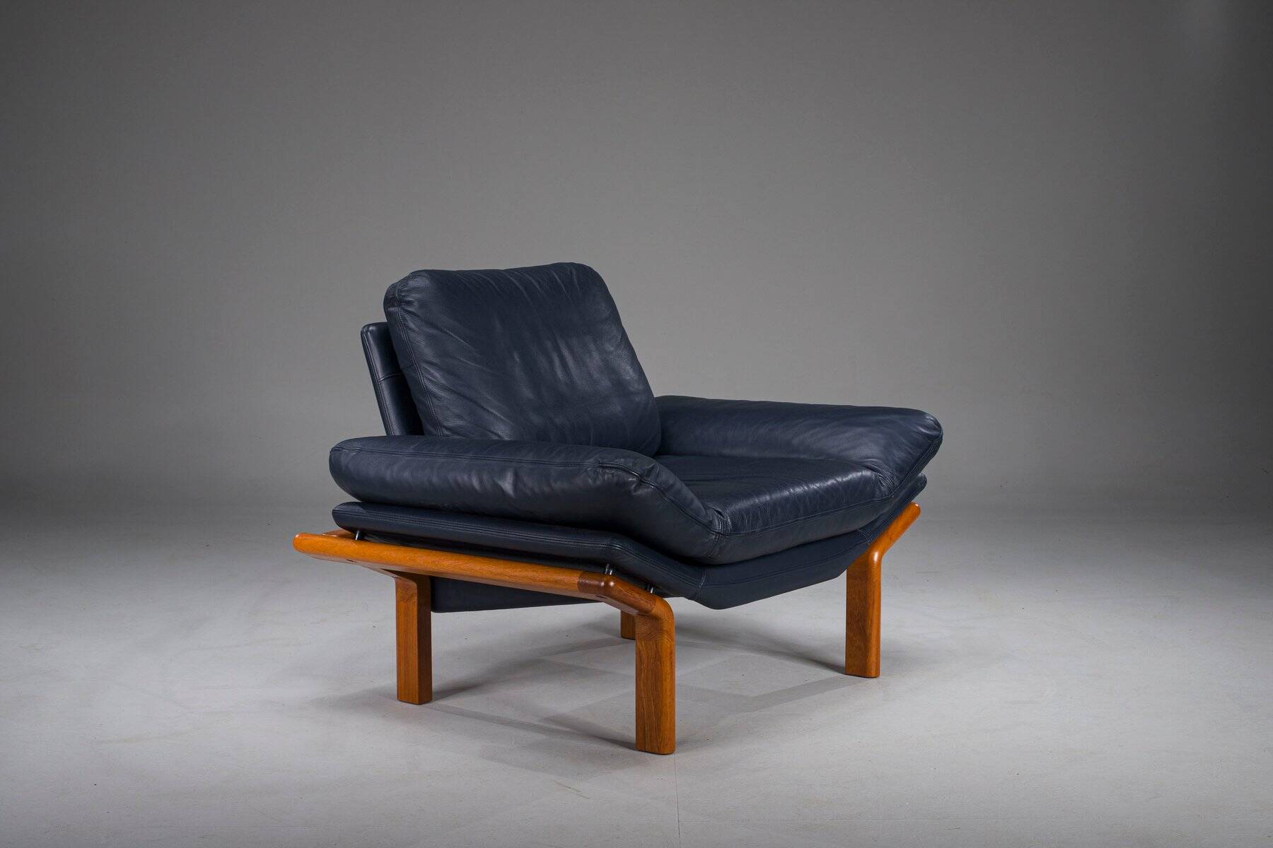 Danish teak and navy blue leather lounge chair from Komfort, 1970s