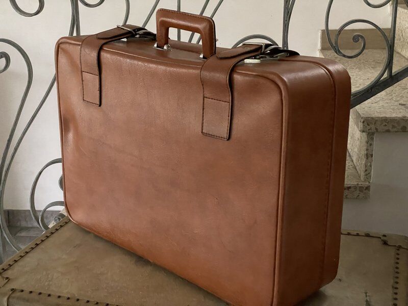 Antique suitcase with brown leather straps