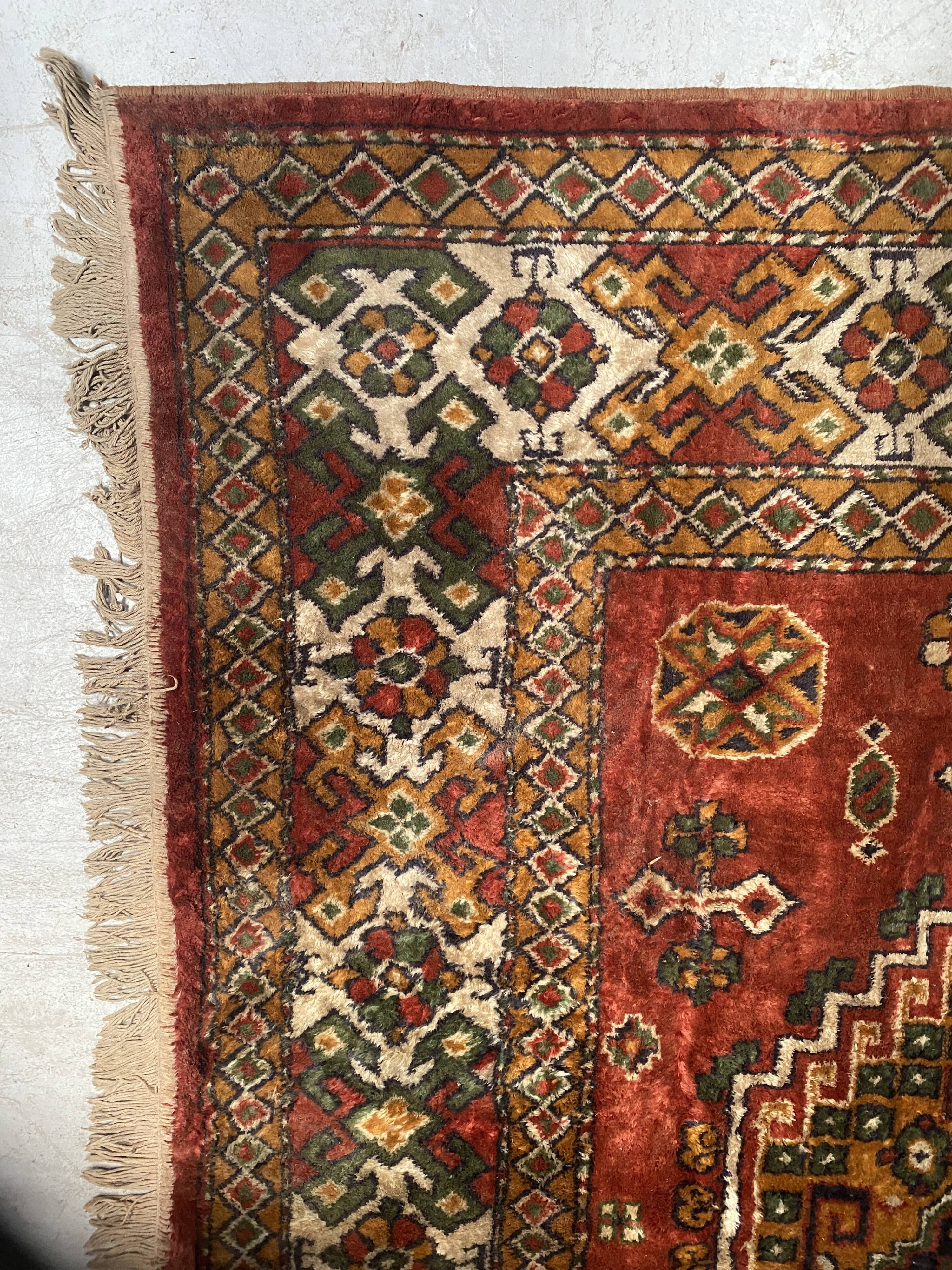Antique wool rugs with designs on a red background, 20th century.