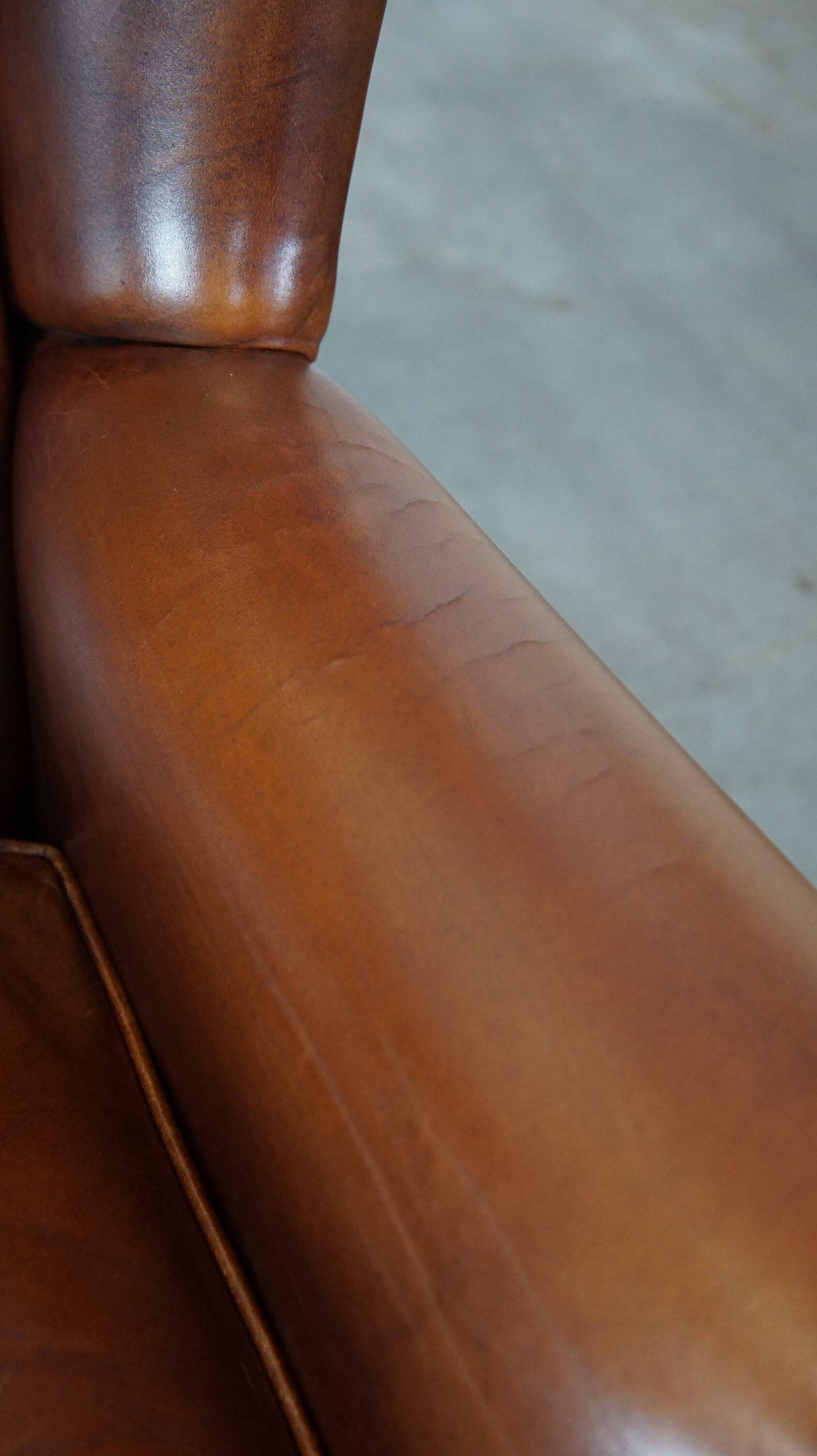Fauteuil à oreilles en cuir de vachette cognac