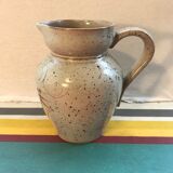 Old gray pitcher with black drawings and vintage stamped handle