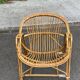 1970s adult rattan and wicker armchair with a round burgundy velvet cushion.
