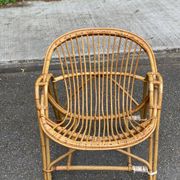 1970s adult rattan and wicker armchair with a round burgundy velvet cushion.