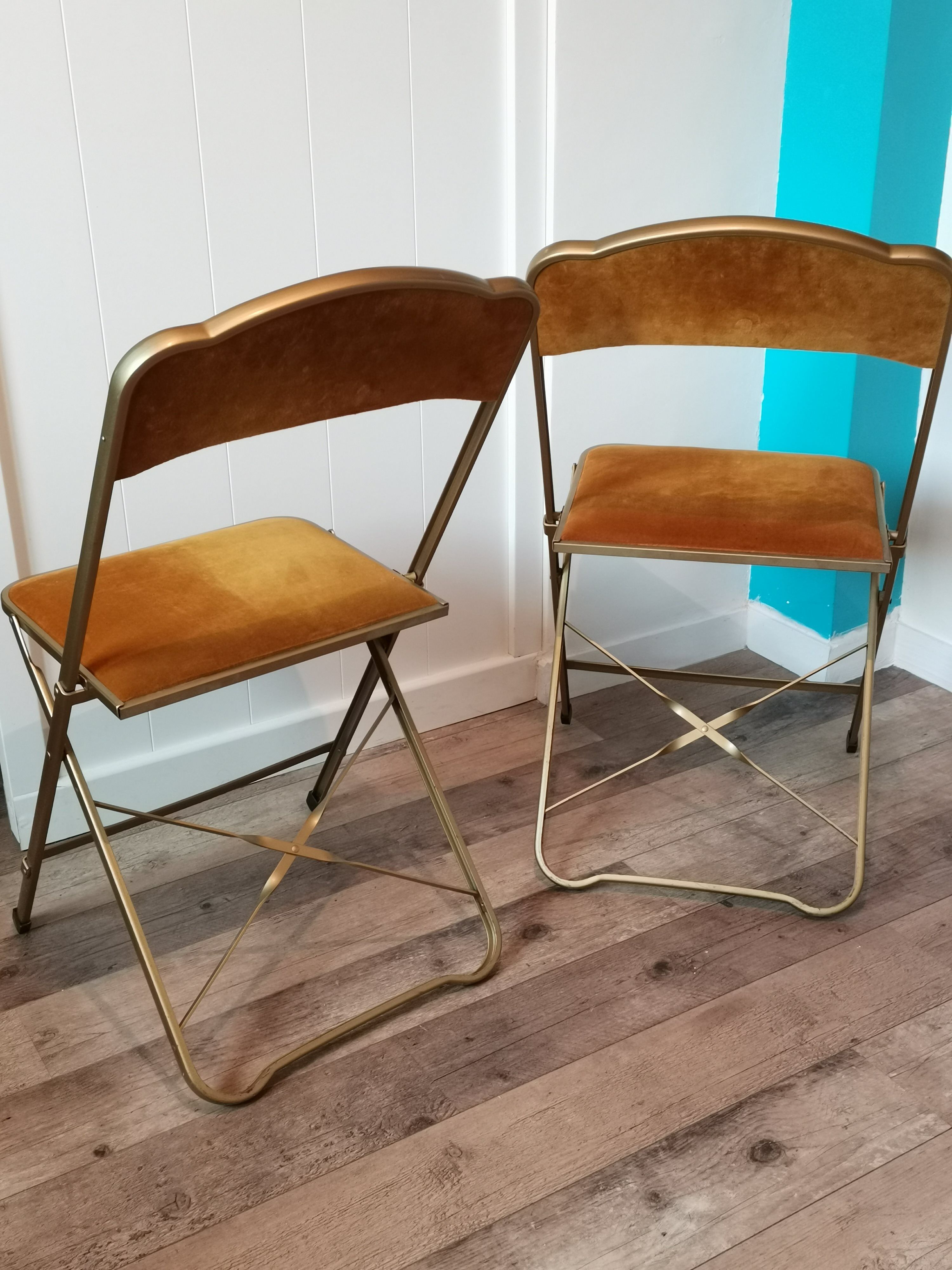 Two gold velvet folding chairs