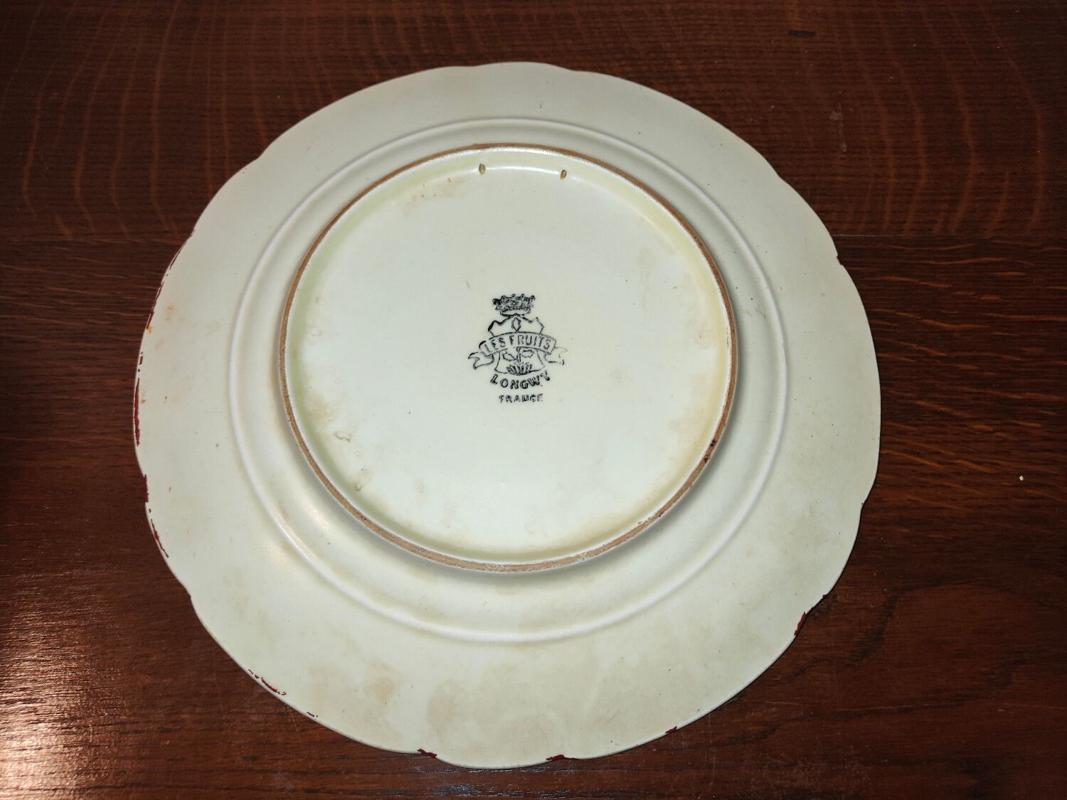 Faience plate in Longwy enamels signed Léa Valenti representing Fruits