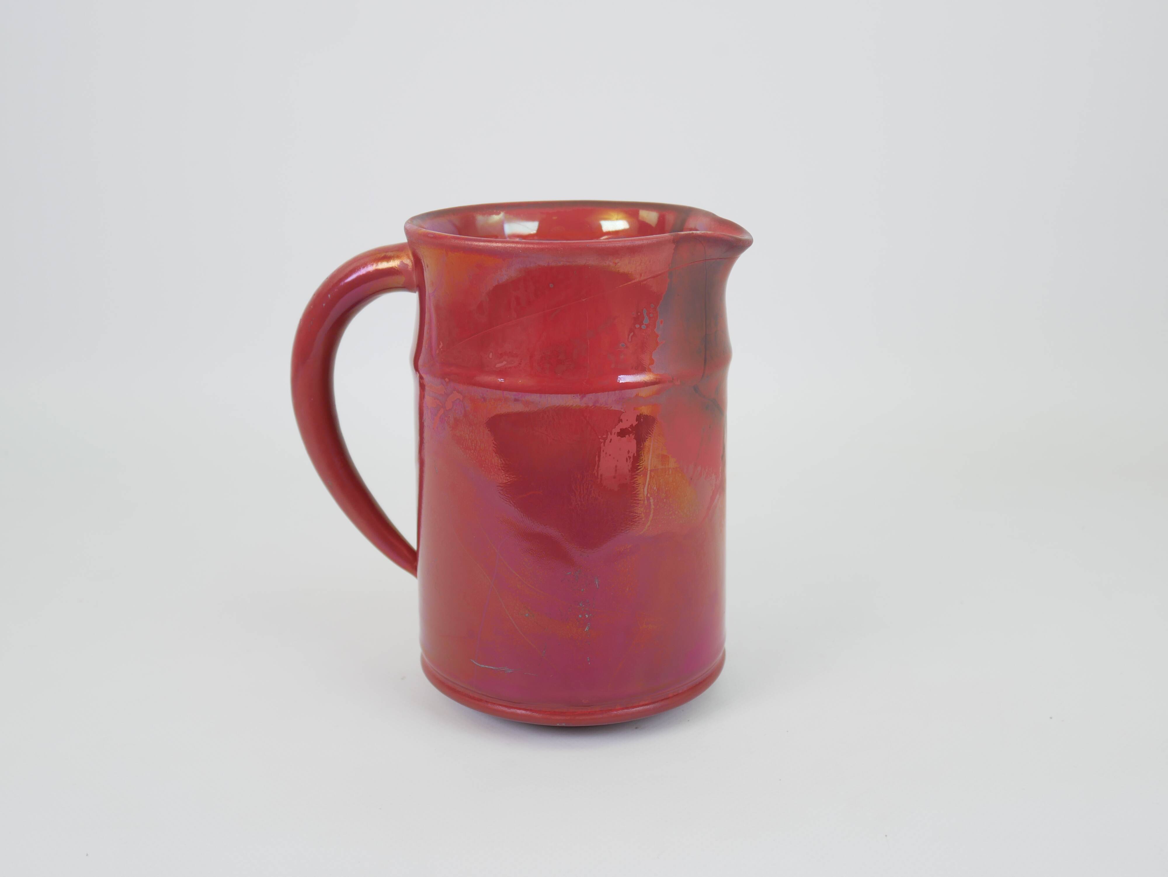Red glazed ceramic jug with relief