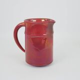 Red glazed ceramic jug with relief