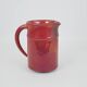 Red glazed ceramic jug with relief
