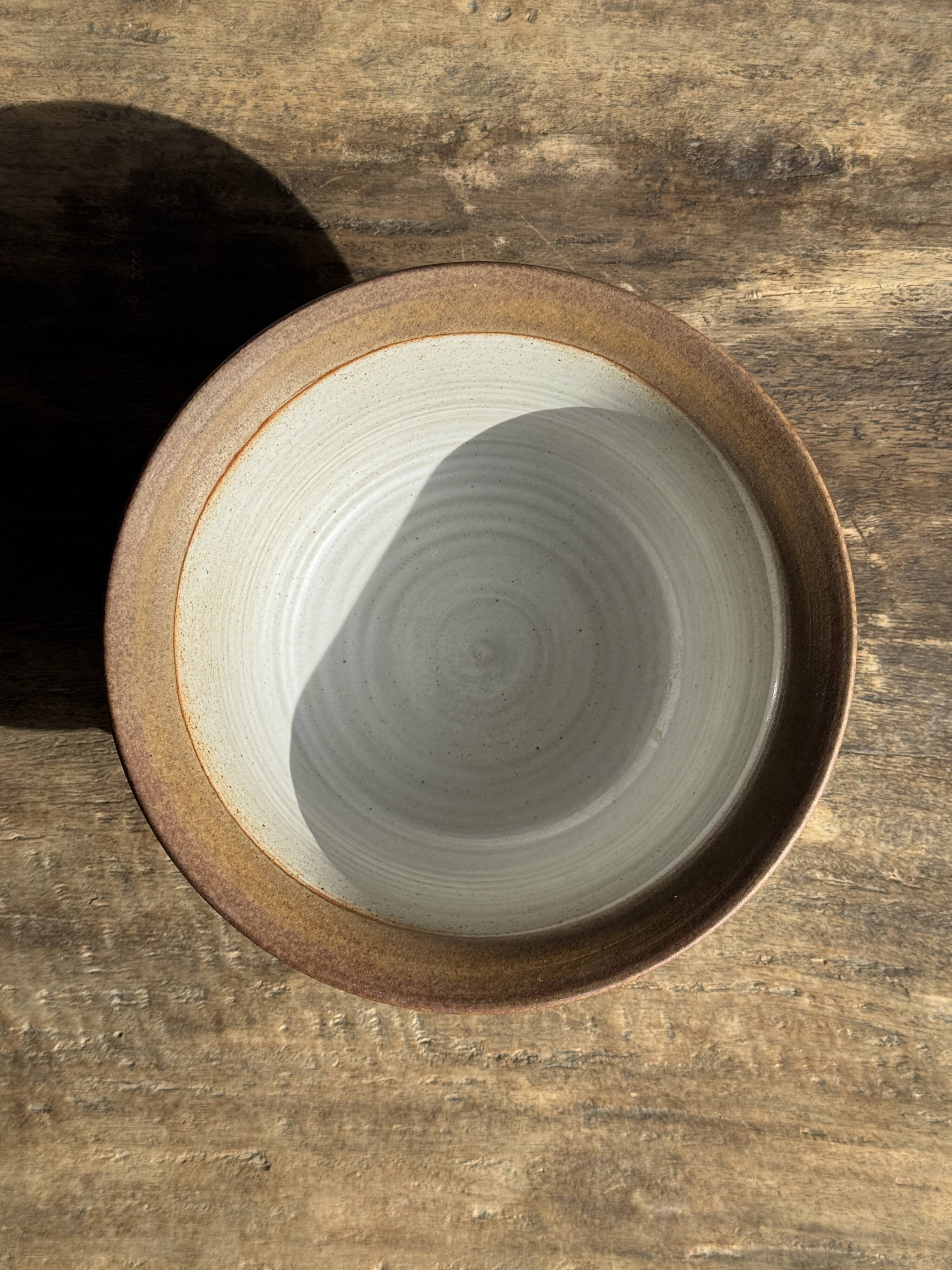 Small thick stoneware bowl with a stylised flower pattern in white on the outside, b