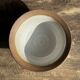 Small thick stoneware bowl with a stylised flower pattern in white on the outside, b