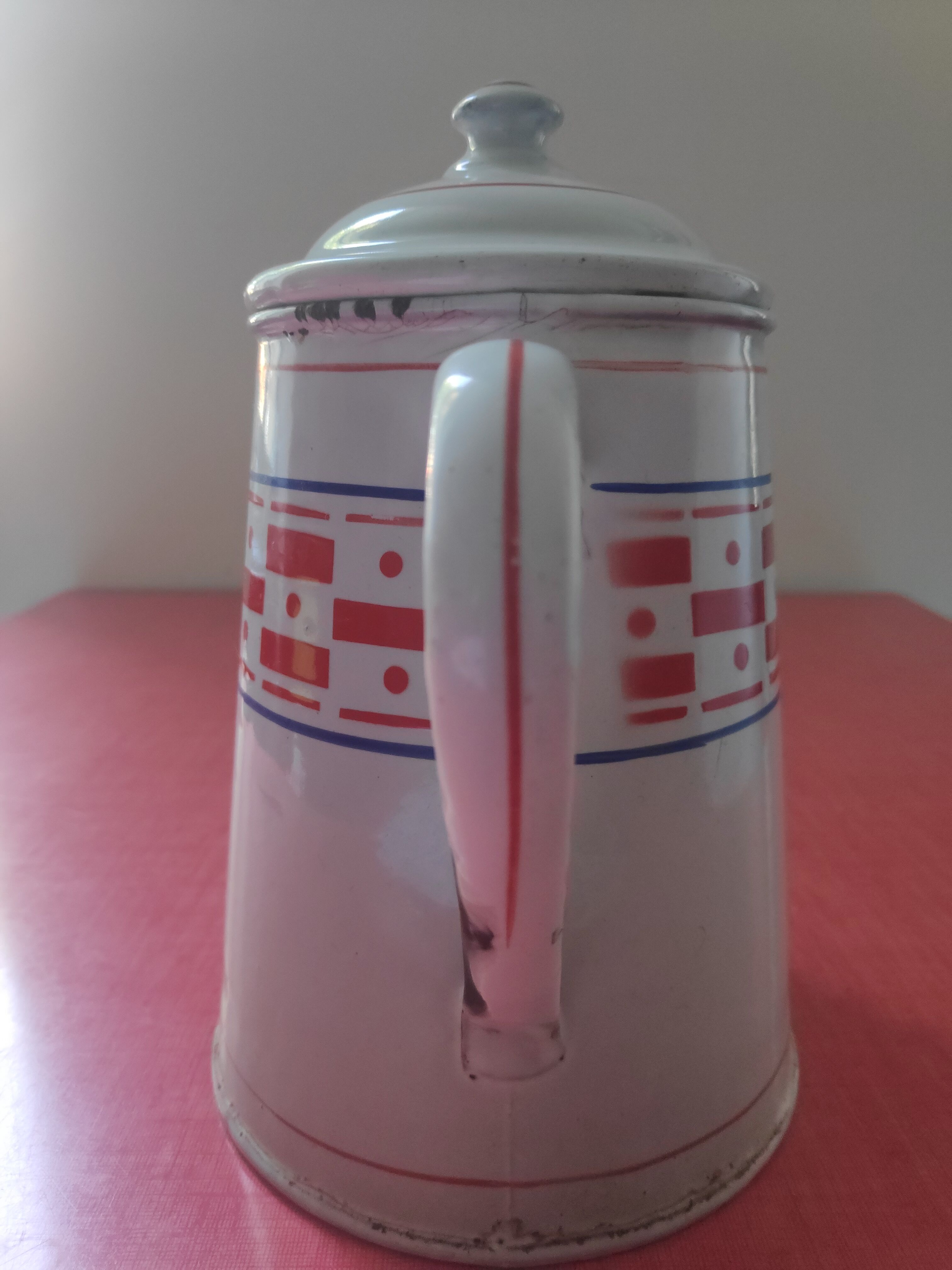 White enamelled sheet metal coffee maker with red and blue patterns