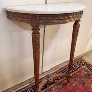 Half-moon console in Louis XVI style made of carved wood.