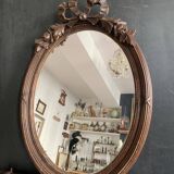 Antique oval mirror in carved wood and Louis XVI style knot