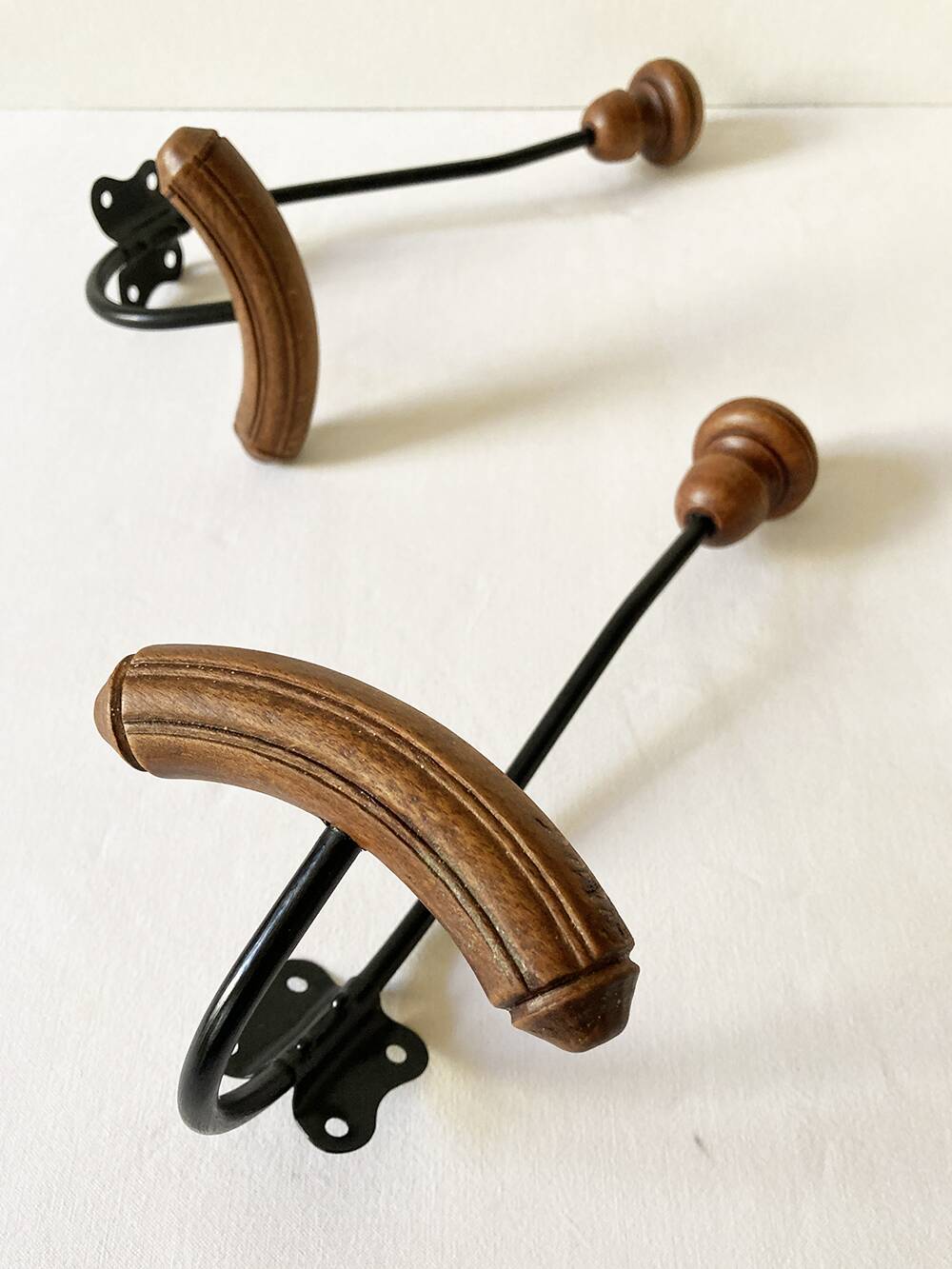 Pair of antique wooden and metal coat hooks