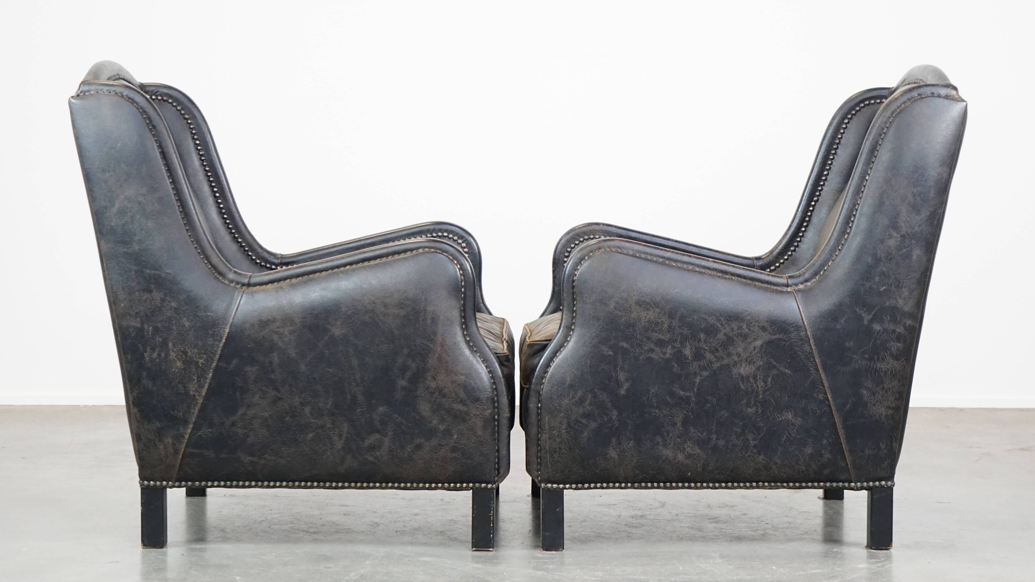 Set of 2 black cow leather armchairs finished with decorative nails, industrial style