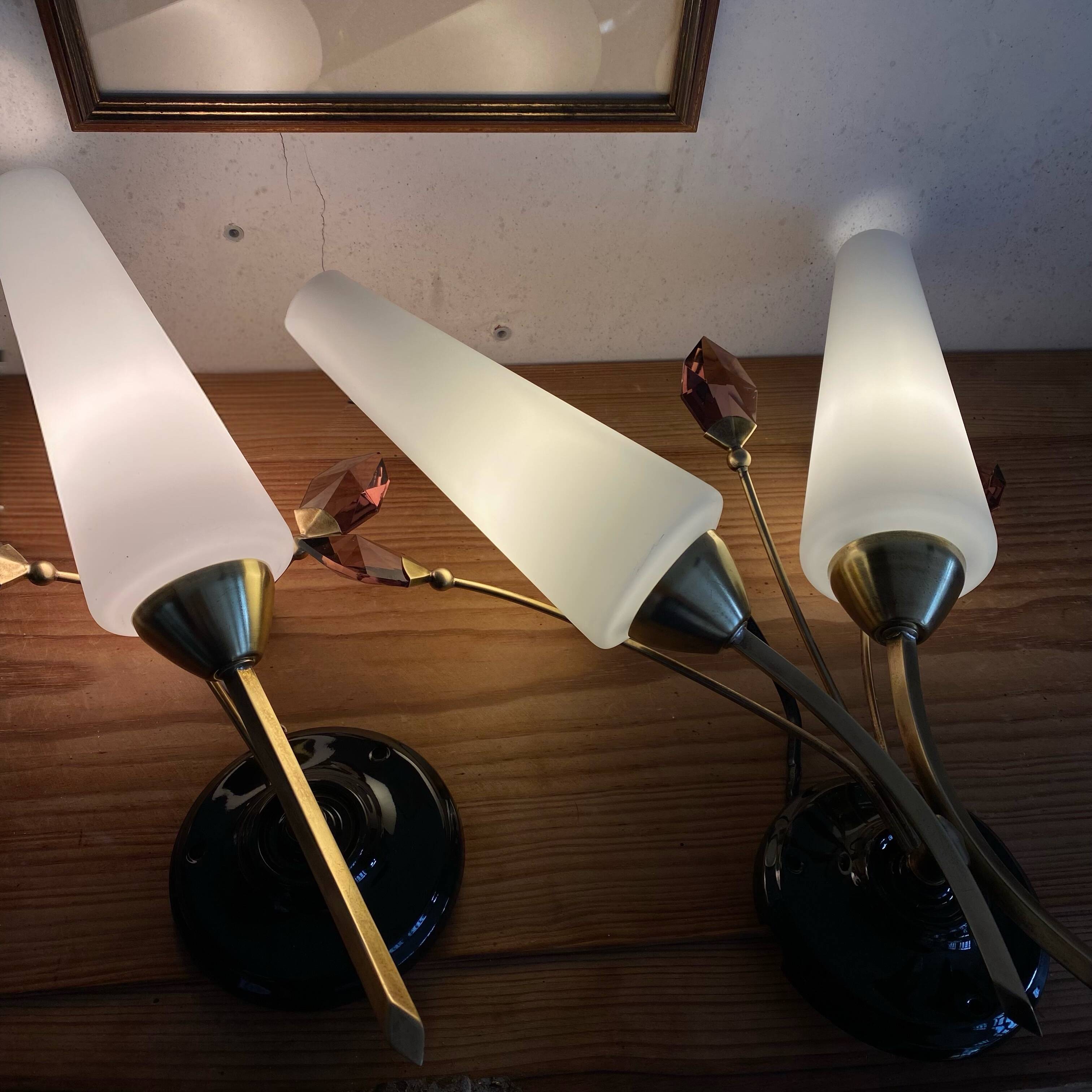 Pair of wall sconces in brass with white glass tulips.