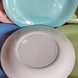 Seven pastel-colored plates mixed with vintage earthenware