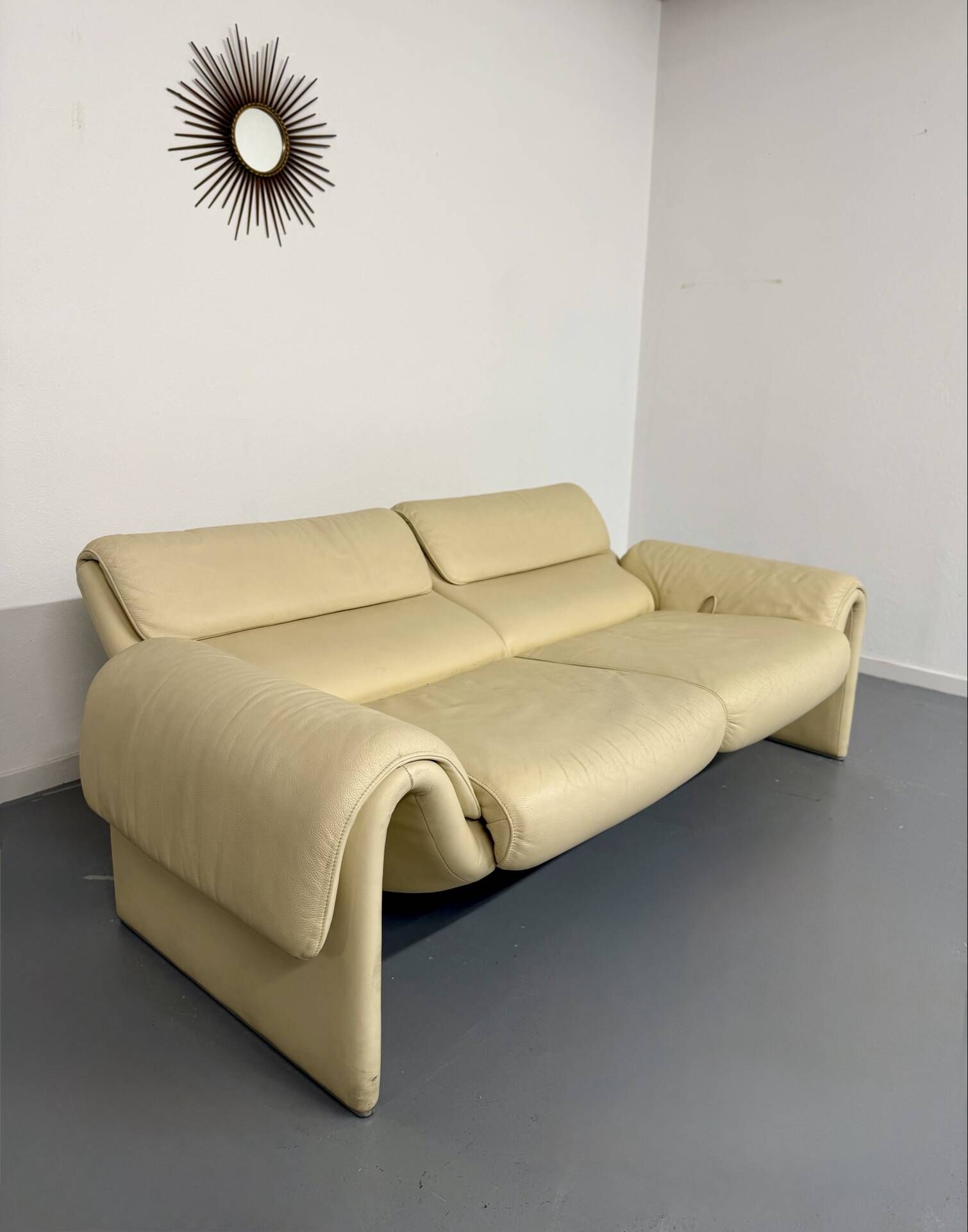 Two-seater designer sofa De Sede DS-2011 in cream leather with adjustable backrest.