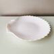 White ceramic dish shaped like 80s shells