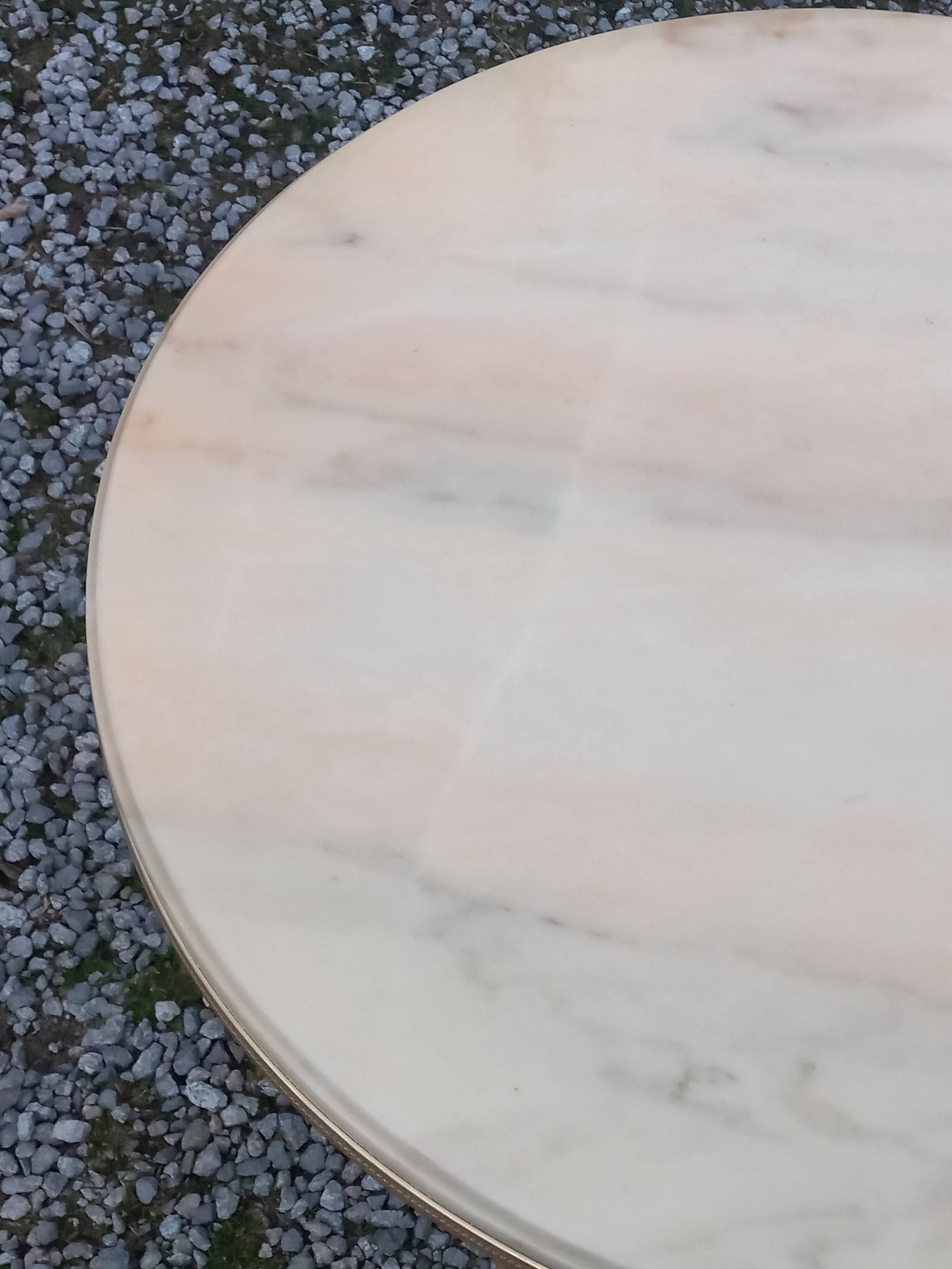 Round neoclassical coffee table with a marble top and golden metal base.