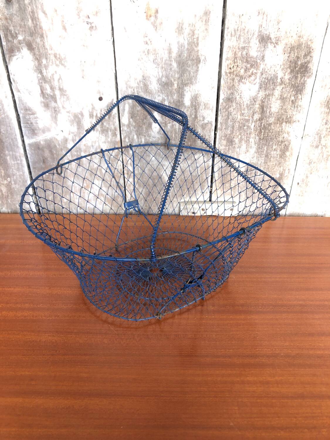 Old foldable blue metal basket, vintage handles