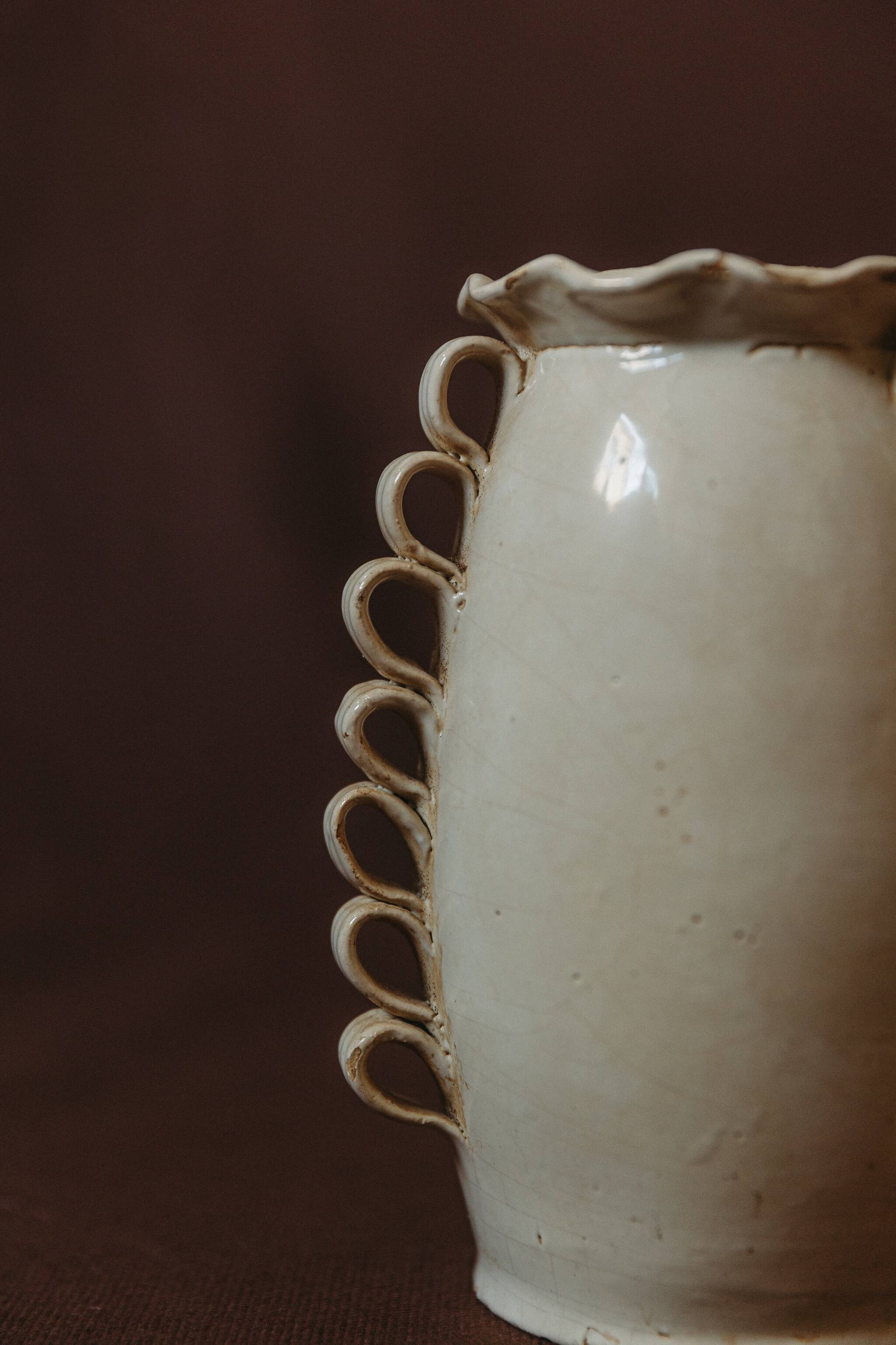 White glazed stoneware vase decorated with raised ribbons.