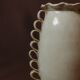 White glazed stoneware vase decorated with raised ribbons.