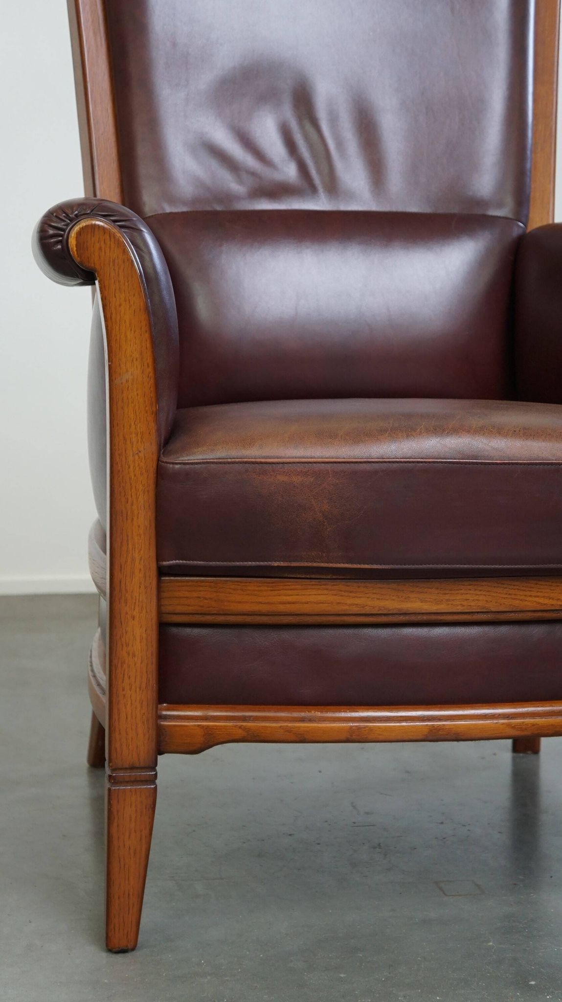 Very comfortable classic cowhide armchair with a high back in a mild Art Deco style