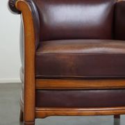Very comfortable classic cowhide armchair with a high back in a mild Art Deco style