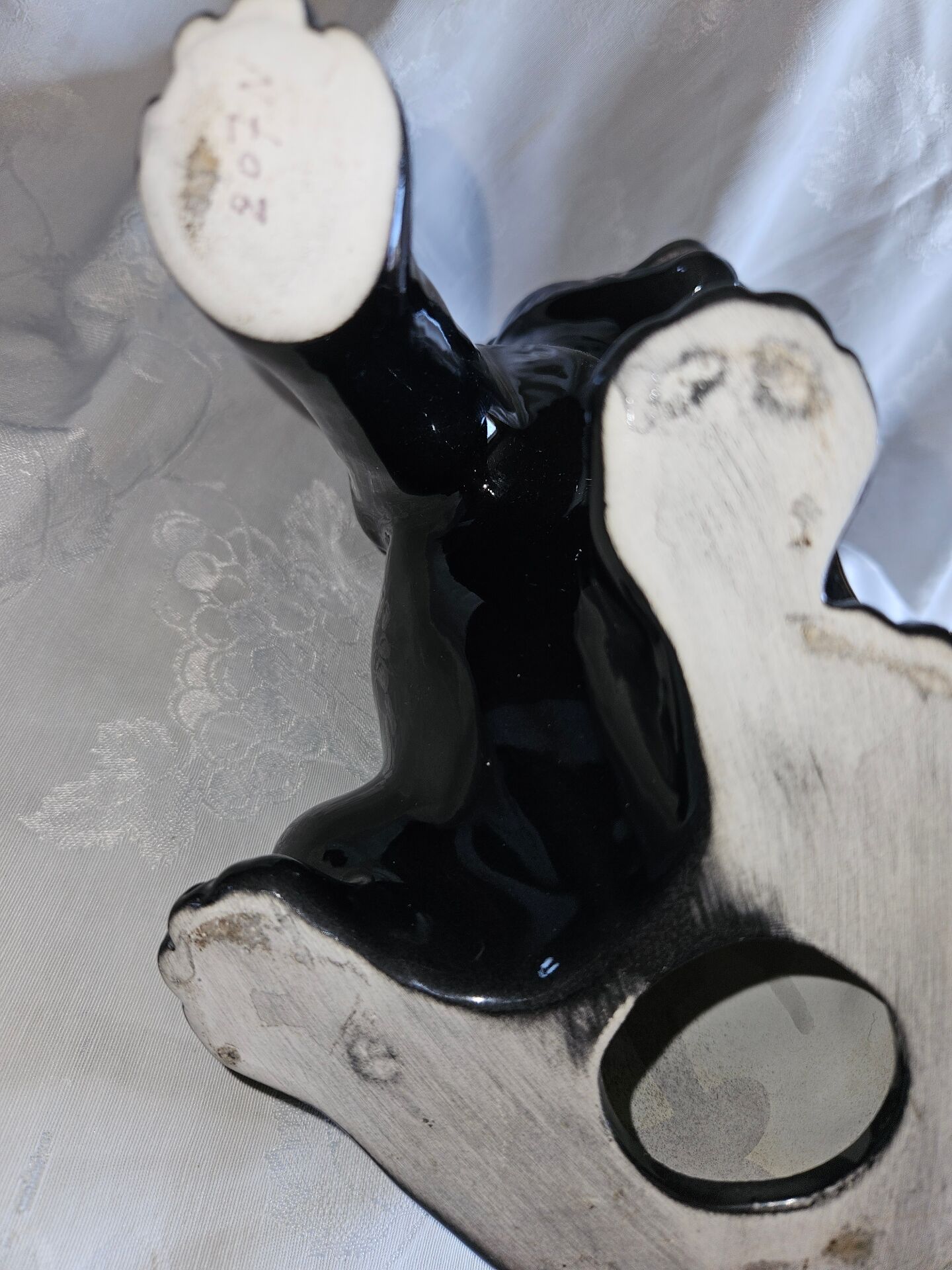 Statue of a roaring panther/leopard sitting in black glazed ceramic.