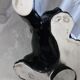 Statue of a roaring panther/leopard sitting in black glazed ceramic.