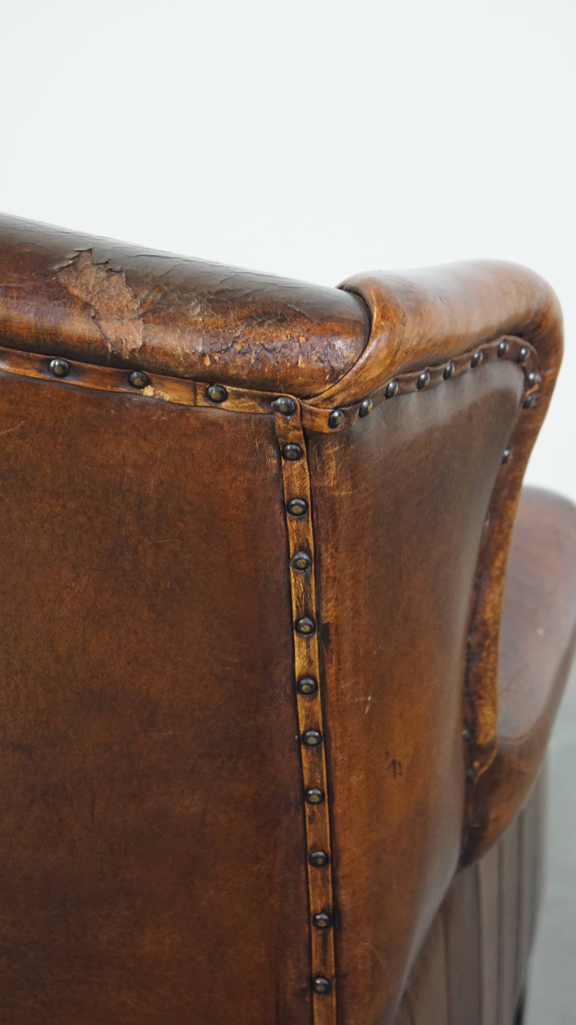 Sheepskin leather wingback chair with a red corduroy seat cushion