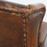 Sheepskin leather wingback chair with a red corduroy seat cushion