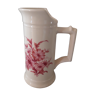 Pitcher vase with bouquet of pink flowers