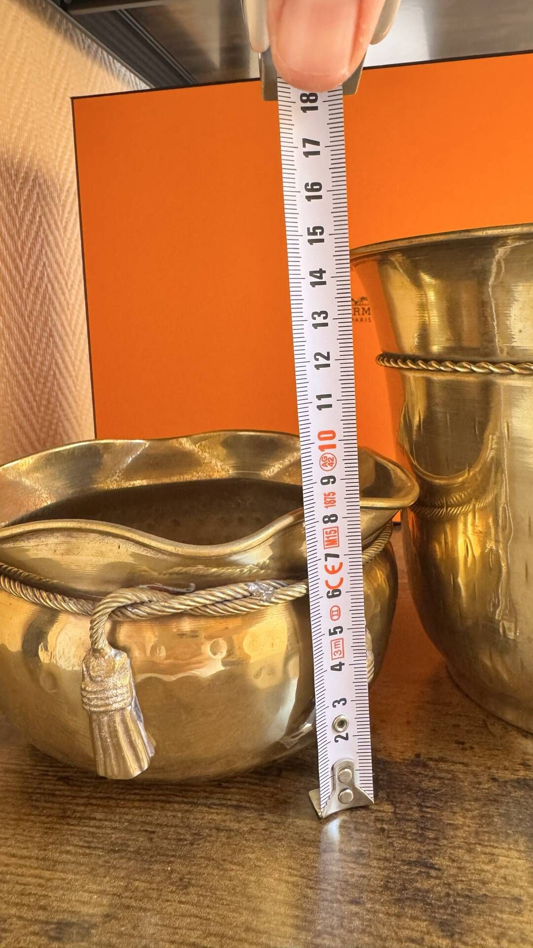 Pair of brass plant pots, decorated with cord and tassels.