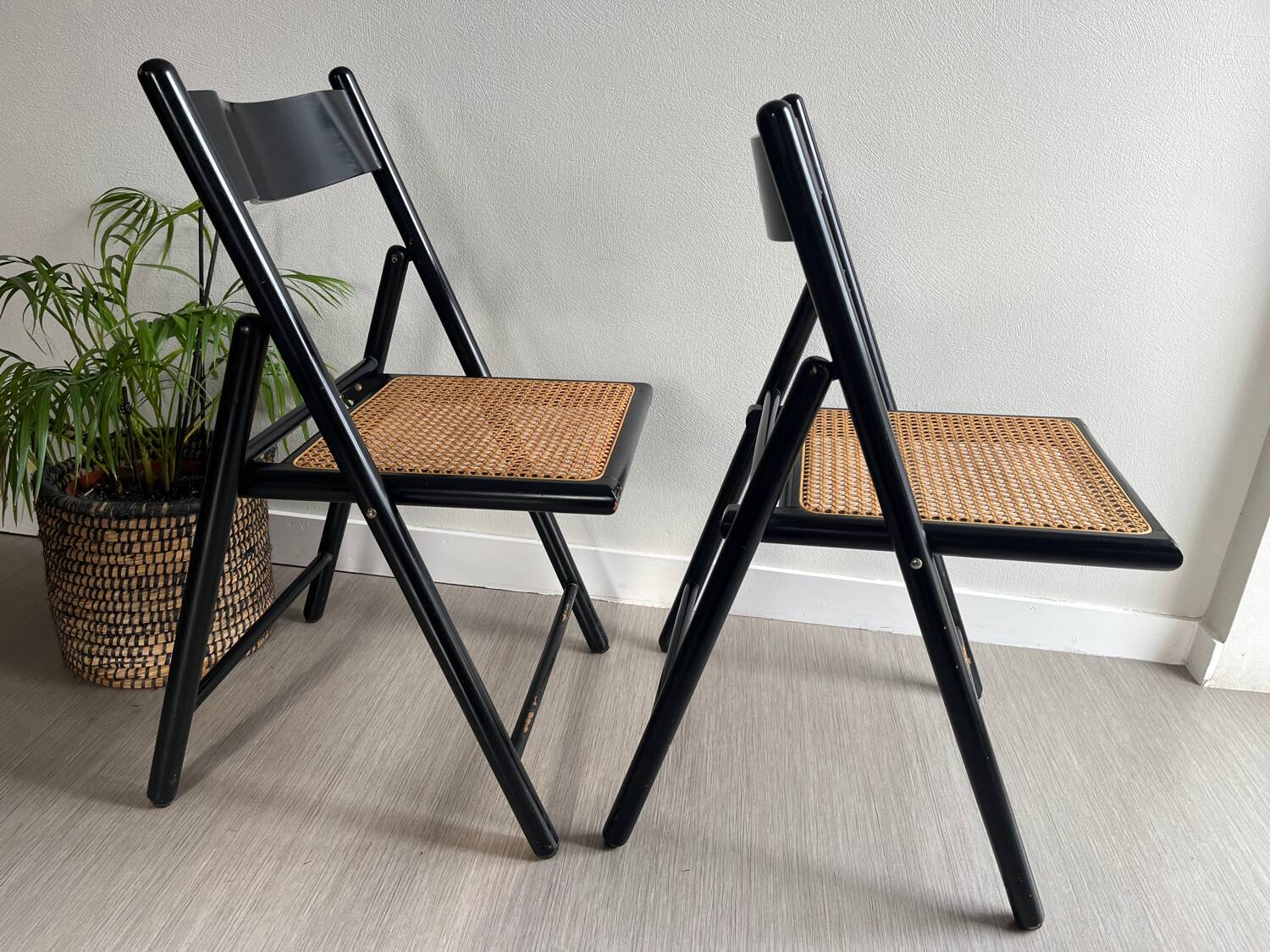 Vintage folding chairs in black wood and cane.