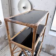 Rattan bookshelf and black glasses