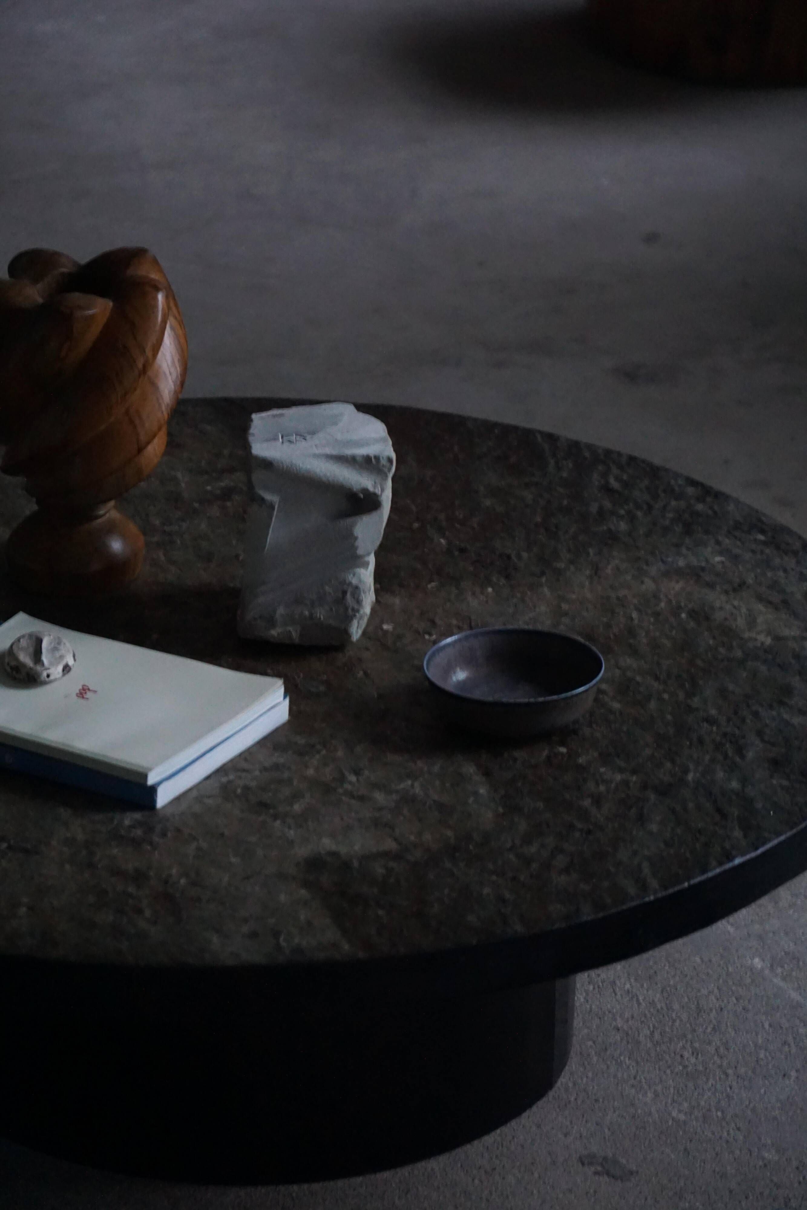 Round brutalist coffee table in stone and steel, mid-century French modernism, 1970s.