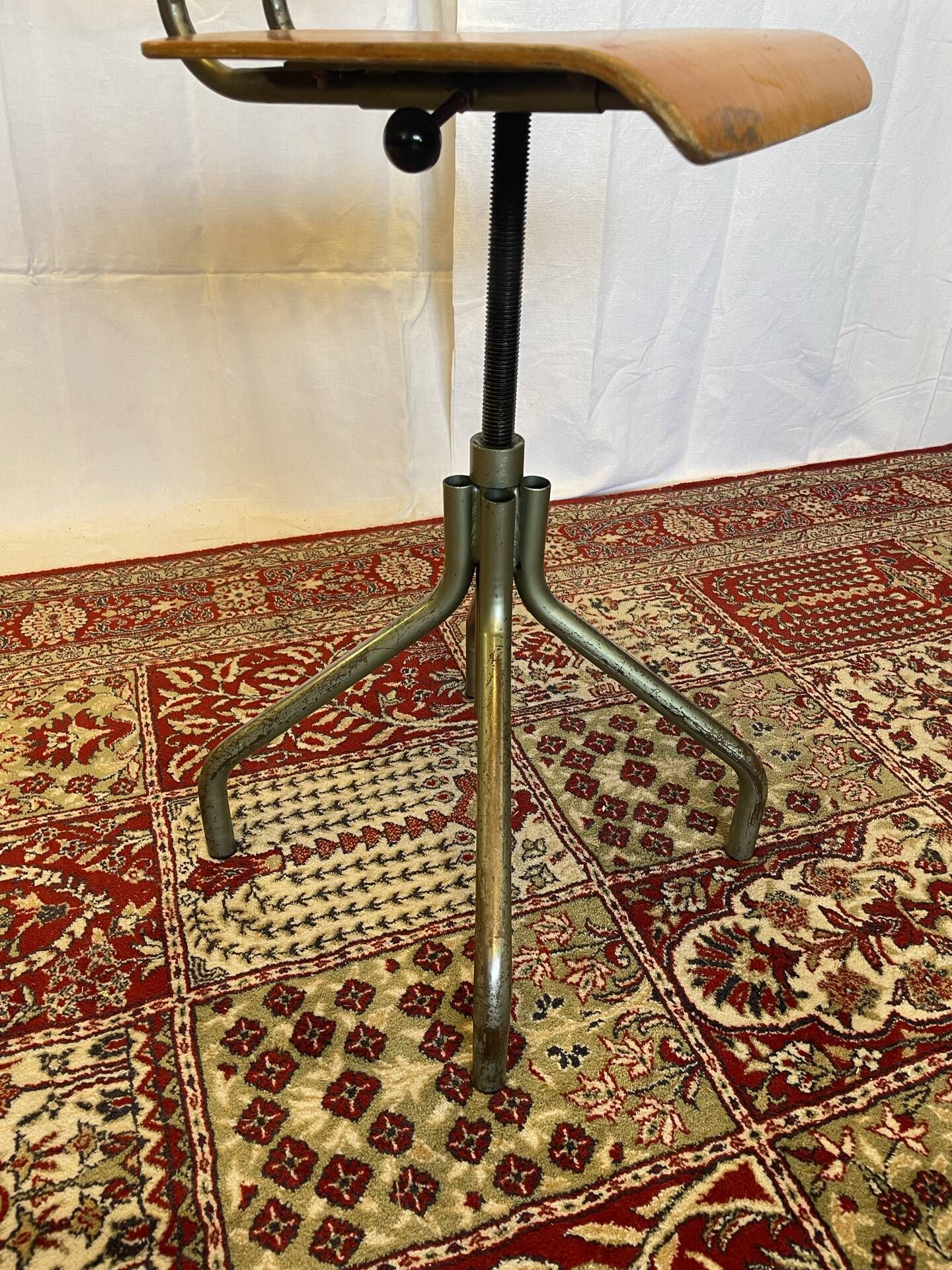 Old high workshop chair made of wood and metal.