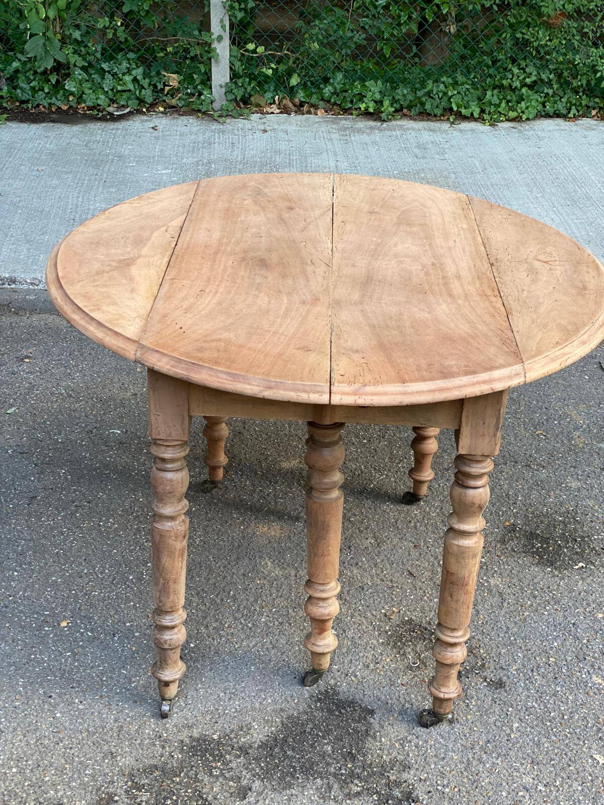 Renovated round extendable dining table with leaves made of solid wood.