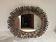 Large oval sun mirror in patinated gold metal.