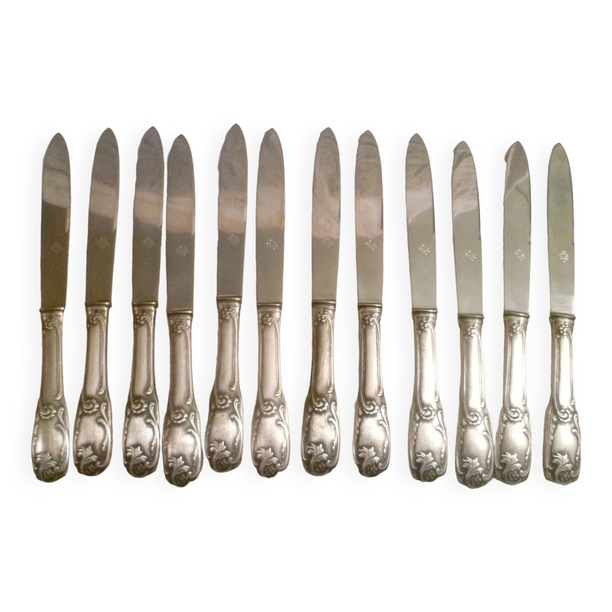 12 couteaux de table en metal argente modele "feuillages" lames inox