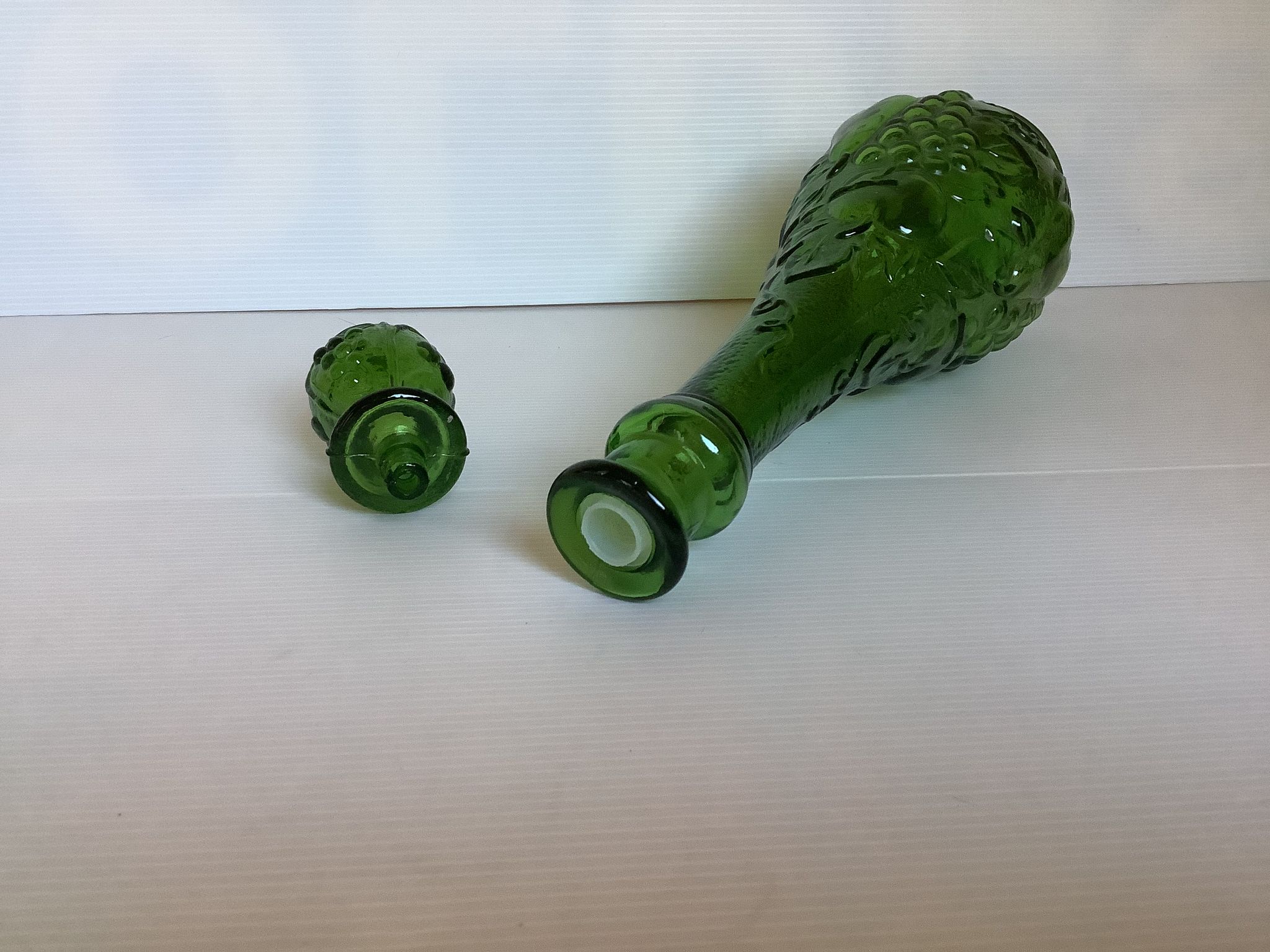 Green carafe bottle with apple, pear, and grape pattern from Italy.