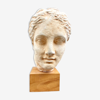 Plaster head of an ancient goddess on its wooden base
