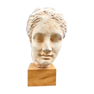 Plaster head of an ancient goddess on its wooden base