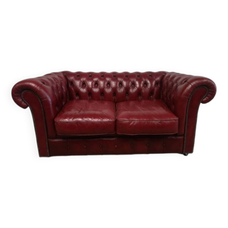 Red two-seater chesterfield sofa