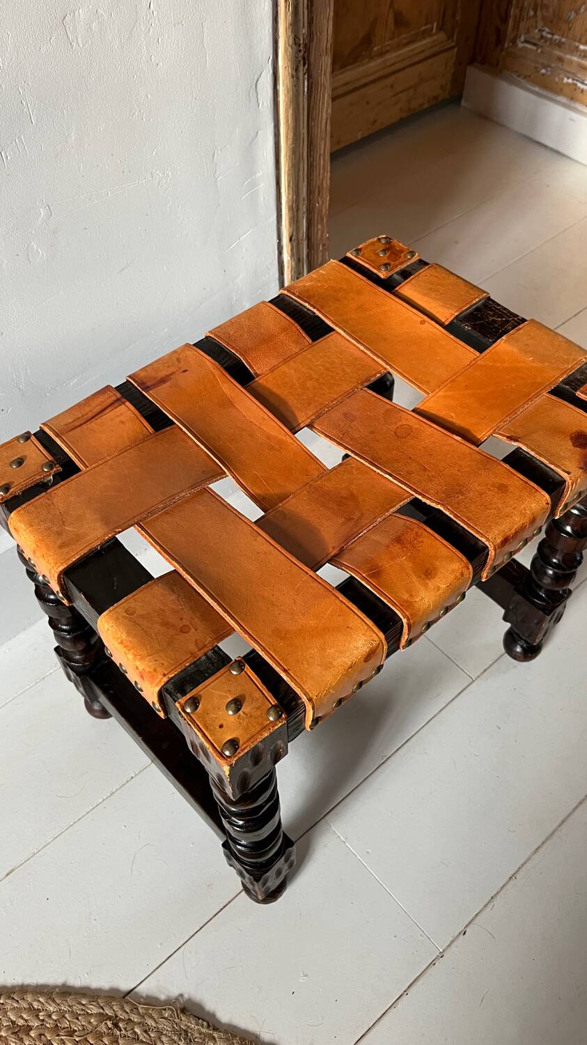 Antique turned wooden stool with woven leather.